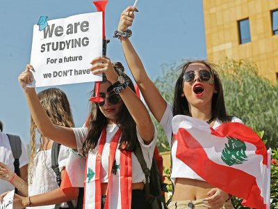 Une étudiante libanaise brandit une pancarte sur laquelle est écrit "Nous étudions pour un avenir qu'on a pas", devant le ministère de l'Education à Beyrouth, le 8 novembre 2019 - ANWAR AMRO [AFP]