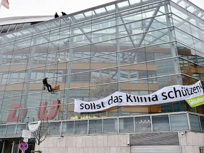 Des militants de Greenpeace écrivent "Tu dois protéger le climat" en enlevant le C du nom du parti CDU à Berlin le 21 novembre 2019 - Paul Zinken [dpa/AFP]