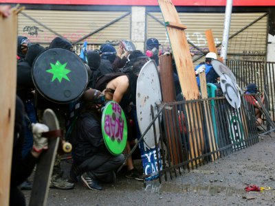 Des manifestants se protègent face aux forces de l'ordre à Santiago, le 22 novembre 2019 - Martin BERNETTI [AFP]