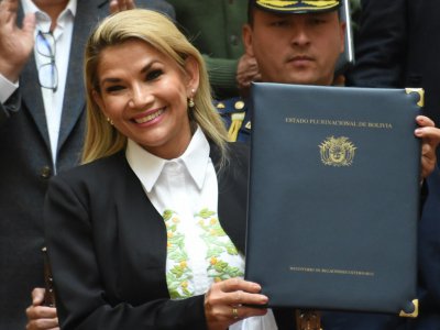 La présidente bolivienne par interim Jeanine Anez montre le document signé convoquant de nouvelles élections présidentielle et législatives en Bolivie, à La Paz le 24 novembre 2019 - AIZAR RALDES [AFP]