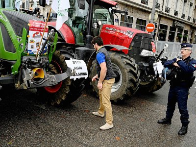Un policier est positionné près de tracteurs lors d'une manifestation d'agriculteurs le 22 octobre 2019 à Lyon - JEAN-PHILIPPE KSIAZEK [AFP/Archives]