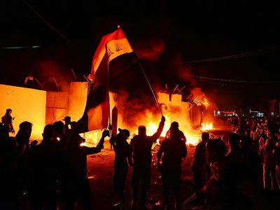 Des manifestants irakiens devant le consulat iranien en flammes dans la ville sainte chiite de Najaf, dans le sud de l'Irak, le 27 novembre 2019 - [AFP]