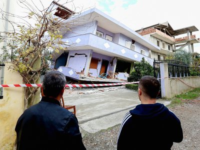 Des Albanais observent une maison effondrée le 28 novembre 2019 à Durres sur la côte Adriatique après un séisme meurtrier - Gent SHKULLAKU [AFP]