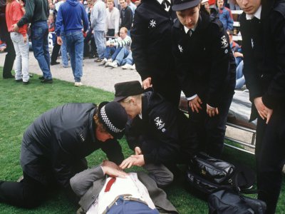Les secours s'occupent de blessés au stade d'Hillsborough (Royaume-Uni) le 15 avril 1989, où une bousculade a coûté la vie à 96 personnes - STRINGER [AFP/Archives]