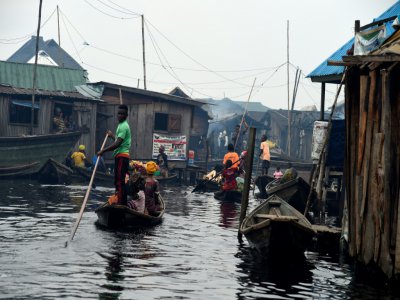 Des habitants se déplacent en pirogue, dans le bidonville flottant de Makoko, à Lagos, le 23 octobre 2019 au Nigeria - PIUS UTOMI EKPEI [AFP]