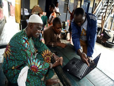 Un membre de l'ONG Code for Africa enseigne à des volontaires comment utiliser un logiciel pour cartographier le bidonville de Makoko, à Lagos, le 23 octobre 2019 au Nigeria - PIUS UTOMI EKPEI [AFP]