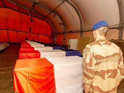 Un soldat français devant les cercueils des 13 militaires de la Force Barkahne morts dans un accident d'hélicoptère, à Gao (Mali), le 27 novembre 2019 (photo du Sirpa, Service d'information et de relations publiques des armées) - James WILLIAM [SIRPA/AFP/Archives]