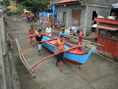 Des habitants de Legaspi City, province d'Albay, au sud de Manille, mettent une embarcation à l'abri avant l'arrivée du typhon Kammuri - RAZVALE SAYAT [AFP]