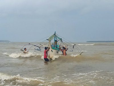 Des Philippins mettent en sécurité un bateau de pêche sur la côte à Borongan, dans le centre des Philippines, le 2 décembre 2019 à l'approche du typhon Kammuri - Alren BERONIO [AFP]