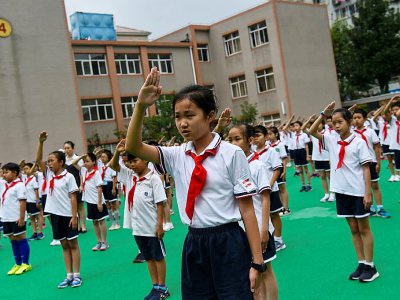 Des élèves à Shangaï chantent l'hymne chinois lors d'une cérémonie dans leur école, en septembre 2017 - Chandan KHANNA [AFP/Archives]