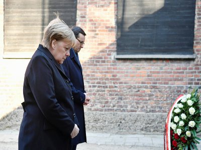 La chancelière allemande Angela Merkel et le Premier ministre polonais 
 Mateusz Morawiecki se recueillent après avoir déposé une gerbe au camp nazi d'Auschwitz-Birkenau, en Pologne, le 6 décembre 2019 - John MACDOUGALL [AFP]