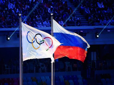 Les drapeaux olympique et russe flottent au vent lors de la cérémonie de clôture des JO Sotchi, le 23 février 2014 - Andrej ISAKOVIC [AFP/Archives]