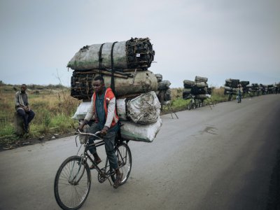 Des cyclistes transportent des sacs de charbon de bois pour les vendre à Goma, le 28 septembre 2019 en RDC - ALEXIS HUGUET [AFP]