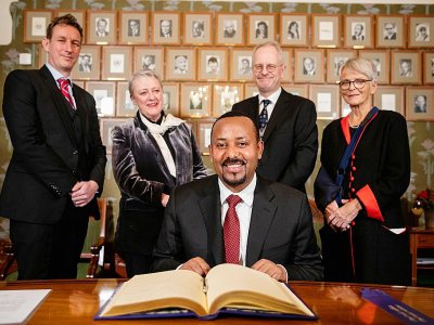 Le Premier ministre éthiopien Abiy Ahmed Ali (c) signe le registre Nobel, en présence des membres du Comité Nobel, le 9 décembre 2019 à Oslo, en Norvège - Tore Meek [NTB Scanpix/AFP]