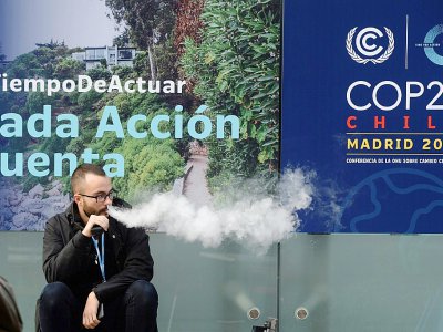 Un homme fume une cigarette électronique à la conférence pour le climat COP25 à Madrid, le 11 décembre 2019 - CRISTINA QUICLER [AFP]