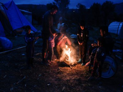 Des migrants kurdes originaires de Syrie allument un feu dans le camp de migrants de l'île de Chios en Grèce, le 11 décembre 2019 - LOUISA GOULIAMAKI [AFP]