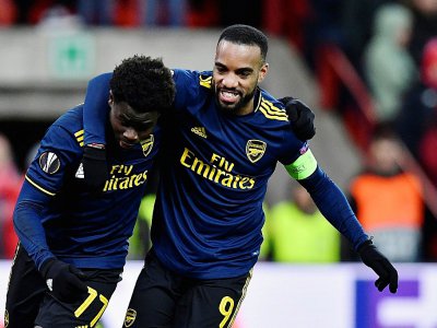 Les attaquants d'Arsenal Bukayo Saka (g) et Alexandre Lacazette heureux après un but du premier sur le terrain du Standard de Liège en Ligue Europa, le 12 décembre 2019 - JOHN THYS [AFP]