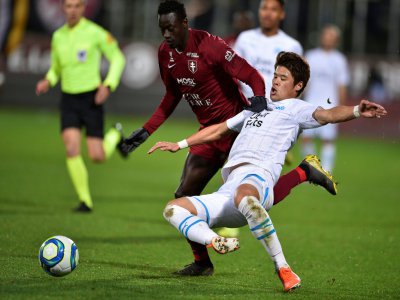 L'attaquant sénégalais de Metz Ibrahima Niane (g) à la lutte avec le défenseur japonais de Marseille Hiroki Sakai, le 14 décembre 2019 au stade Saint-Symphorien - JEAN-CHRISTOPHE VERHAEGEN [AFP]