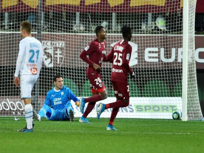 L'attaquant sénégalais de Metz Opa Nguette (c) vient d'ouvrir la marque contre Marseille et son gardien de but remplaçant Yohann Pelé (au sol), le 14 décembre 2019 au stade Saint-Symphorien - JEAN-CHRISTOPHE VERHAEGEN [AFP]