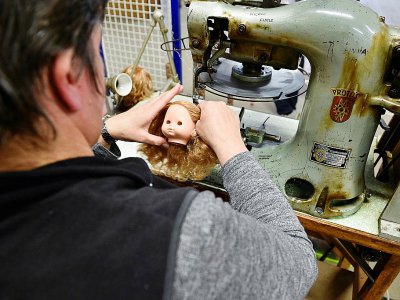 Une employée de Petitcollin fixe les cheveux à la tête d'une poupée dans l'atelier de fabrication, le 29 novembre 2019 à Etain, dans la Meuse - JEAN-CHRISTOPHE VERHAEGEN [AFP]