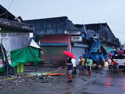 Des habitants devant des bâtimments détruits par un puissant séisme, à Padada dans la province de Davao del Sur sur l'île de Mindanao aux Philippines le 15 décembre 2019 - FERDINANDH CABRERA [AFP]