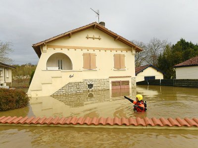 Un pompier passe dans une zone complètement inondée de Peyrehorade, le 14 décembre 2019 dans les Landes - GAIZKA IROZ [AFP]