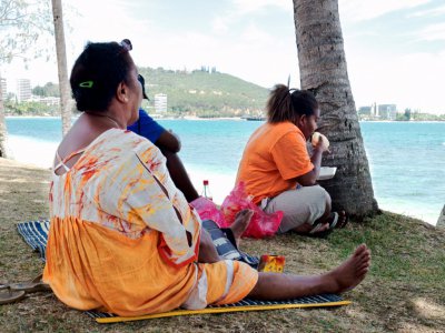 Une famille atteinte d'obésité mange à la plage à Nouméa, le 1er décembre 2014 - THEO ROUBY [AFP]