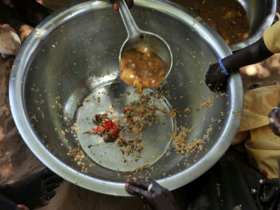Des mains posées sur une assiette presque vide, servie à des familles dans le village de Merine Dakhar (Sénégal), le 29 mai 2008 - GEORGES GOBET [AFP/Archives]