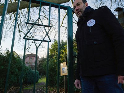 Un volontaire des "veilleurs de mémoire", Lionel Godmet, devant la porte du cimetière juif de Jungholtz, dans l'est de la France, le 10 décembre 2019 - SEBASTIEN BOZON [AFP]