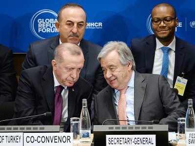 Le secrétaire général de l'ONU Antonio Guterres (d),  le président turc Recep Tayyip Erdogan (g) et le ministre turc des Affaires étrangères Mevlut Cavusoglu (g, derrière) à l'ouverture du Forum sur les réfugiés, le 17 décembre 2019 à Genève - FABRICE COFFRINI [POOL/AFP]