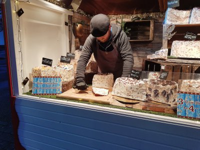 Raymond Rech en train de couper un morceau de nougat caramel beurre salé que l'on va déguster… sur le marché de Noël du Havre. - Joris Marin