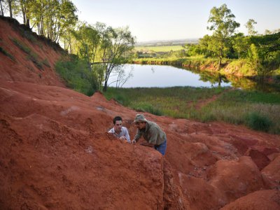 Paleontologists Rodrigo Temp Muller (L) and Jose Darival Ferreira examine a newly found fossil at a dig site in Agudo, Brazil - CARL DE SOUZA [AFP]