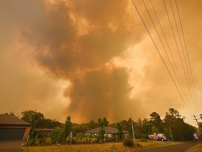 Des fumées d'incendie près de maisons à Bargo, en banlieue de Sydney (Australie), le 21 décembre 2019 - PETER PARKS [AFP/Archives]