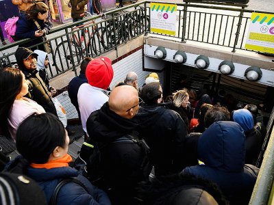 Des voyageurs attendent que les grilles du métro s'ouvrent le 20 décembre 2019 à la station Porte d'Orléans à Paris - Bertrand GUAY [AFP]