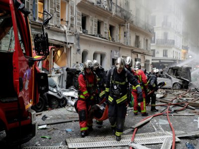 Des pompiers évacuent des blessés après une explosion rue de Trévise à Paris le 12 janvier 2018 - Thomas SAMSON [AFP/Archives]