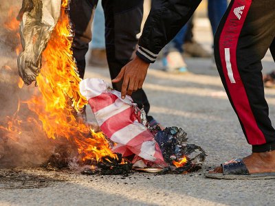 Des Irakiens brûlent le drapeau américain pour protester contre la présence des Etats-Unis, à Bassora, dans le sud de l'Irak, le 30 décembre 2019 - Hussein FALEH [AFP]