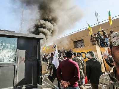 Des membres et partisans du Hachd al-Chaabi, coalition de paramilitaires dominée par des factions pro-Iran, incendient une tourelle devant l'ambassade des Etats-Unis à Bagdad le 31 décembre 2019 - Ahmad AL-RUBAYE [AFP]