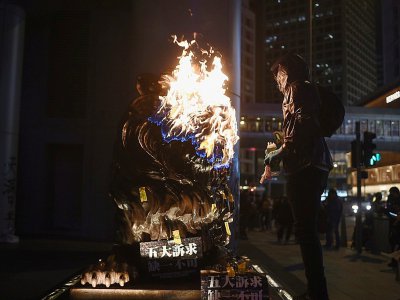 Un manifestant incendie une statue de lion installée devant le siège de la banque HSBC à Hong Kong, en marge d'une manifestation pro-démocratie le 1er janvier 2020 - Philip FONG [AFP]