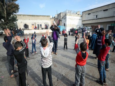 Des enfants jouent dans la cour d'une prison transformée en centre d'accueil pour les déplacés à Idleb, le 31 décembre 2019 - Omar HAJ KADOUR [AFP]