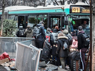 Des usagers tentent de monter dans un bus près de la Gare Montparnasse à Paris, le 2 janvier 2020, au 29e jour de grève dans les transports - STEPHANE DE SAKUTIN [AFP]