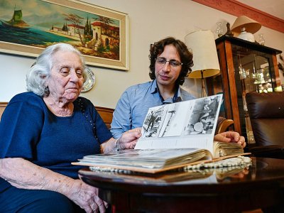 Evrensel Rodrik (à droite) et sa grand-mère Dora Beraha regardent un album de photos de famille, en décembre 2019 à Istanbul - Ozan KOSE [AFP]