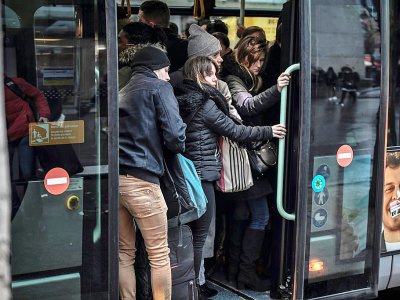 Des usagers tentent de monter dans un bus le 2 janvier 2020 à Paris - STEPHANE DE SAKUTIN [AFP]