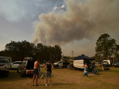 Des personnes se sont réfugiées sur la plage pour fuir un incendie à Batemans Bay en Australie, le 4 janvier 2020 - PETER PARKS [AFP]