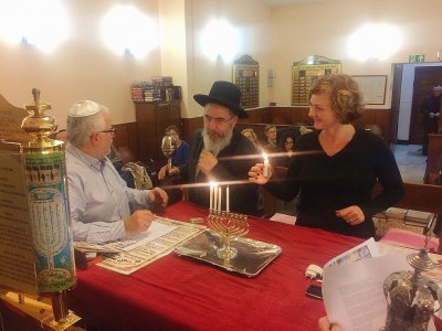 Une catéchiste caennaise allume une bougie (du nom de ménorah) à côté du rabbin lors de Hanouka, la fête des lumières chez les juifs. Cette fête hivernale dure huit jours. - Nassim Lévy