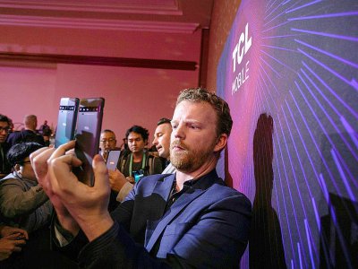 A man uses a new TCL 10 series phone at the TCL news event during the 2020 Consumer Electronics Show (CES) in Las Vegas - DAVID MCNEW [AFP]