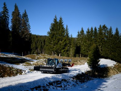 Un membre de l'équipe technique, au volant d'une dameuse, aménage la piste de ski de fond des JO d'hiver de la Jeunesse à Le Brassus près de Lausanne, le 6 janvier 2020 - Fabrice COFFRINI [AFP/Archives]