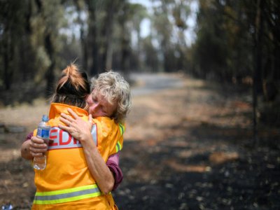 Stephenie Bailey (D) est en larmes en racontant l'incendie de sa maison en Australie, à Batlow en Nouvelle-Galles du Sud (suest-est) le 8 janvier 2020 - SAEED KHAN [AFP]