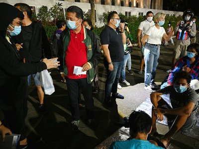 Distribution de masques à des sans-abri pour les protéger des cendres dégagées par le volcan Taal, le 12 janvier 2020 à Manille - Ted ALJIBE [AFP]