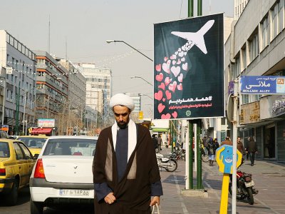 Un Iranien passe devant une affiche rendant hommage aux victimes du crash d'un avion ukrainien abattu "par erreur" par l'Iran, à Téhéran le 13 janvier 2020 - ATTA KENARE [AFP]