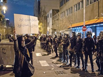 Une manifestante iranienne brandit un panneau sur lequel il est écrit "Votre erreur était non voulue mais votre mensonge était intentionnel", le 11 janvier 2020 à Téhéran - STR [AFP]
